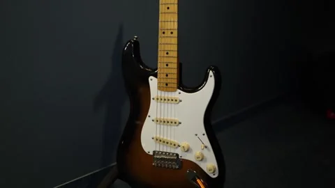 A close-up view of an electric guitar with a classic sunburst finish and white p Stock Footage 293564147