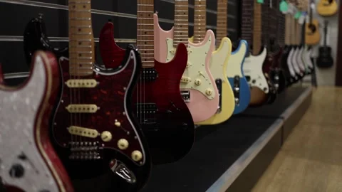 A close-up view of electric guitars with vibrant finishes, from deep reds to sof Stock Footage 294706673