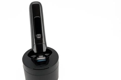 Close-up view of electric shave machine for men on the cleaning pod Stock Photos