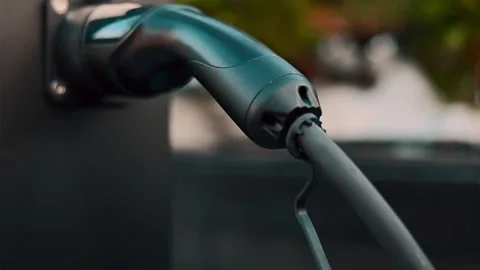 Close up view of electric vehicle charging cable plugged into wall mounted .. 库存影片 339213679