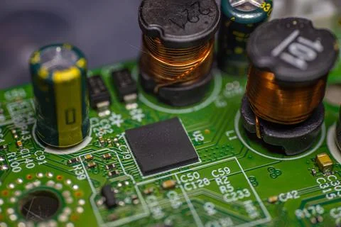 Close-up view of electronic circuit board featuring capacitors, inductors, .. Stock Photos