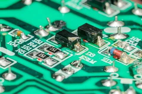 Close-up view of electronic components on a green circuit board with intric.. Photos