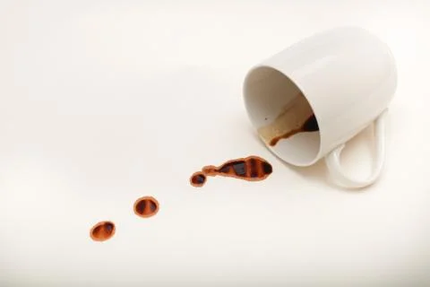 Close up view of empty coffee mug with wet coffee drops on white paper Stock Photos
