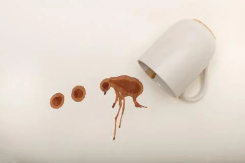 Close up view of empty coffee mug with wet coffee drops on white paper top vi Stock Photos