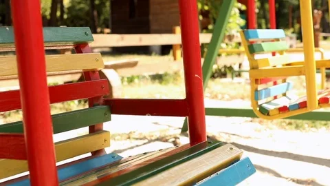 Close-up view of empty colorful bright swings at child playground loop outside 스톡 동영상 115631214