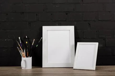 Close up view of empty photo frames and drawing equipment on table Stock Photos