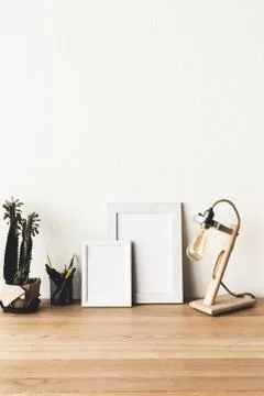 Close up view of empty photo frames on wooden tabletop with table lamp and pl 写真素材