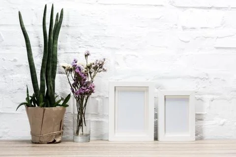 Close up view of empty photo frames and flowers on wooden table Stock Photos