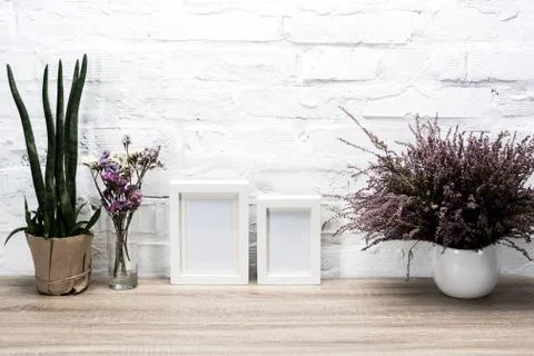 Close up view of empty photo frames and flowers on wooden table Foto stock