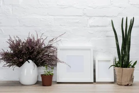 Close up view of empty photo frames and flowers on wooden tabletop Stock Photos