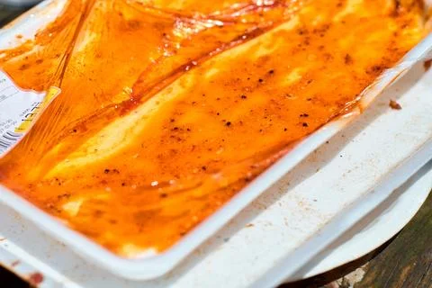 Close-up view of an empty plastic tray with residual glossy meat glaze and .. Stock Photos
