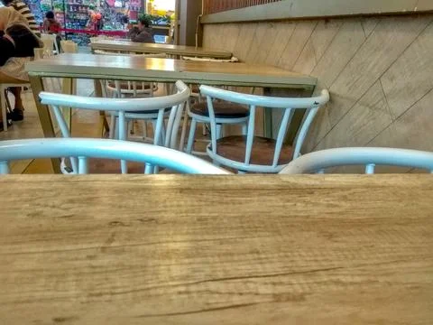 A close-up view of an empty table and chairs in a mall restaurant. Stock Photos