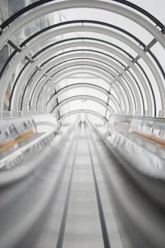 Close Up VIew of an Escalator Operating in a Bright Glass Tunnel Stock Photos