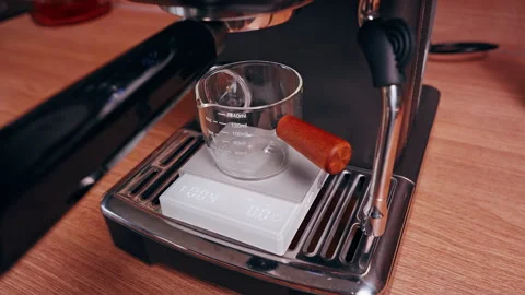 Close Up View of Espresso Flowing Into Glass Measuring Cup on Digital Scale Show Stock Footage 328861750
