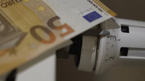 Close view of euro banknotes placed on a household radiator symbolizing heating Stock Footage 324521868
