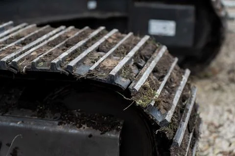 Close view of excavator track segment with soil embedded between raised tread Stock Photos