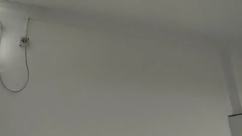 A close-up view of an exhaust fan mounted on a plain white wall Stock Footage 295173227