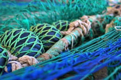 Close-up view of extended fishing nets on the harbor floor Stock Photos