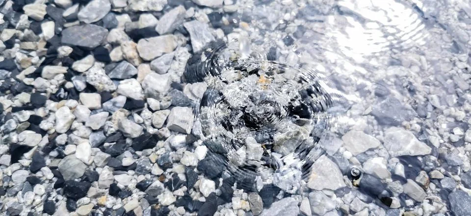 Close-up view (eye-level angle) Raindrops hit the water surface in a circle. Fotos de archivo
