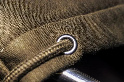 Close-up view of a fabric texture featuring a metal eyelet and zipper, Stock Photos