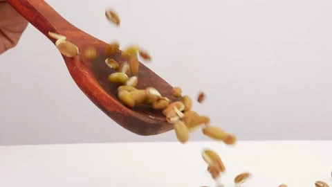 Close view of falling beans seeds over wooden spoon Vídeo Stock 159638474