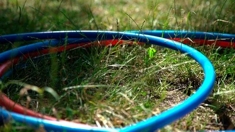 Close up view of falling hula hoop on a green grass. Slow motion. Lose weight.  Stock Footage 123712928