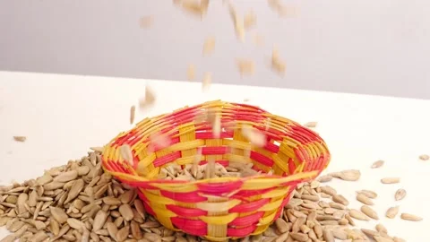 Close view of falling sunflower seeds into craft bowl Video stock 160885848