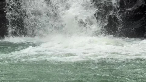 A close view of falling water descends directly into a quiet lake surface, slow Stock Footage 324712138