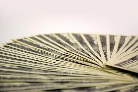 A close-up view of a fan of US dollar bills arranged on a white surface Stock Photos