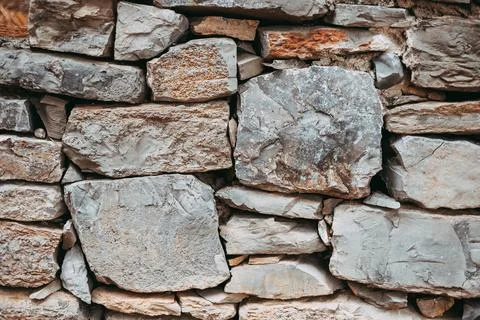 Close-up view features rustic wall made of various stone blocks in different Stock Photos