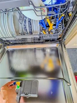 Close up view of female hand inserting dishwasher tablet Stock Photos