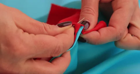 Close view of female hands connect two pieces of fabric together with needles Stock Footage 150444499