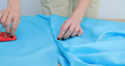 Close view of female hands connect two pieces of fabric together with needles Video stock 150449130
