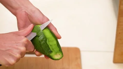 Close up view female hands cutting off avocado peel. Видео 144616452