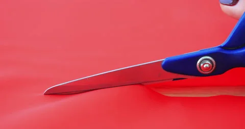 Close view of female hands cutting a red fabric with scissors. Making process Stock Footage 150439605