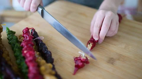Close-up view of female hands cutting Georgian churchkhela candy into pieces Stock-Footage 248230174