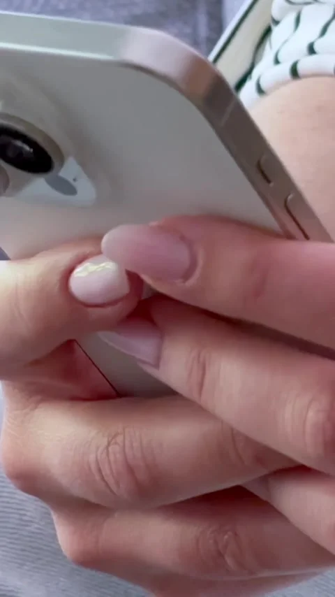 Close up view of female hands with a fresh manicure holding and using a modern Stock Footage 345117086