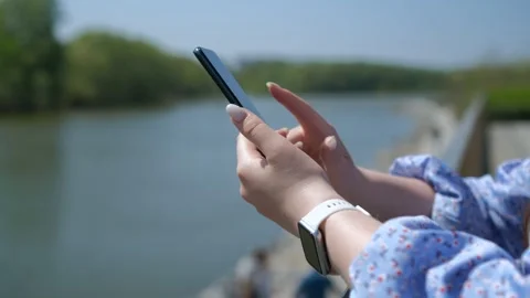 Close-up view of female hands holding smartphone, using the touchscreen Video stock 270962349