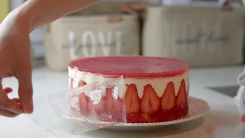Close up view of female hands take the cake mold off the strawberry cake Stock Footage 244828052