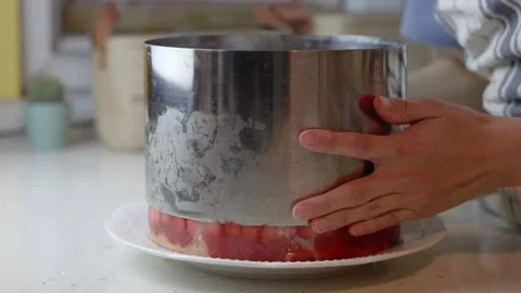 Close up view of female hands take the cake mold off the strawberry cake Stock Footage 244828331