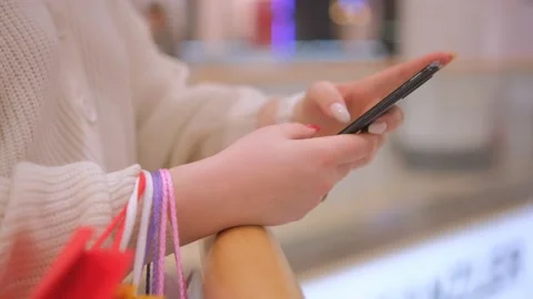 Close view of the female hands using smartphone, texting. Young lady standing at Stock Footage 232492758