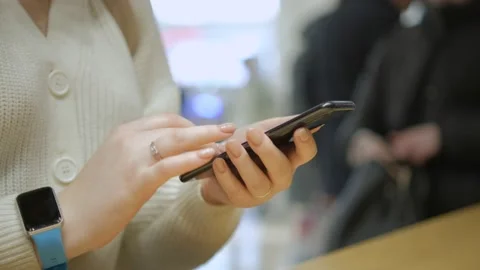 Close view of the female hands using smartphone, texting. Young lady standing at Stock Footage 235164774