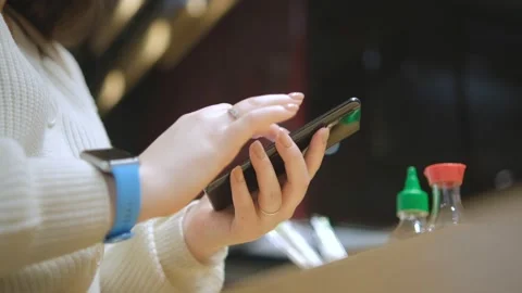 Close view of the female hands using smartphone, texting. Young lady standing at Stock Footage 235453338