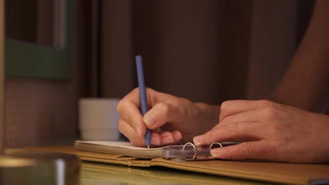 Close up view of female hands that write in notebook. Doing creative homework at Stock Footage 221049080