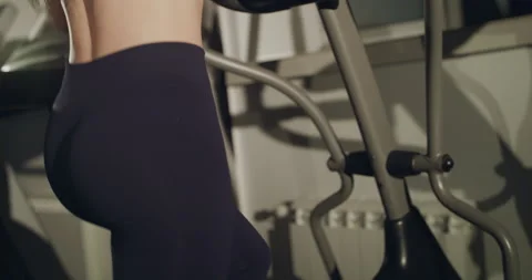 Close view of female inflated buttocks during working out on spin bike in gym Stock Footage 147102210