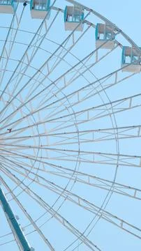 Close view of Ferris wheel cabins on sunny sky background in park setting Stock Photos