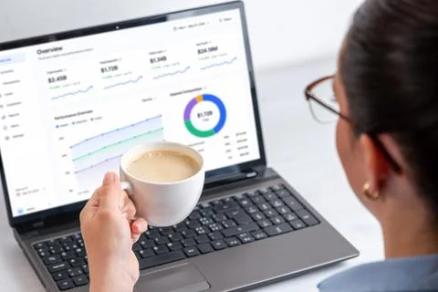 Close view of financial performance dashboard on laptop screen beside coffe.. 스톡 사진