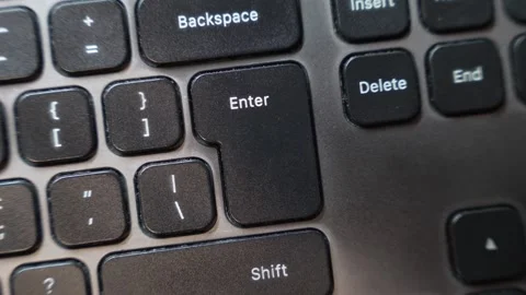 Close up view of a finger pressing the Enter key on a computer keyboard showing Stock Footage 324712100