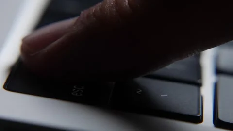 Close view of a finger pressing the Esc key on a laptop keyboard during computer Stock Footage 331247693