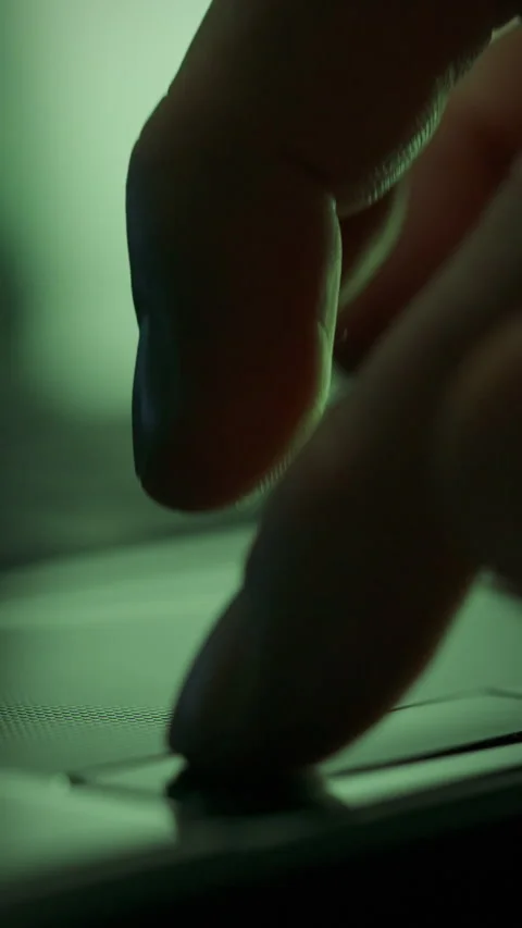Close-up view of a finger tapping on a touchscreen device in a dimly lit env Stock Footage 331533895